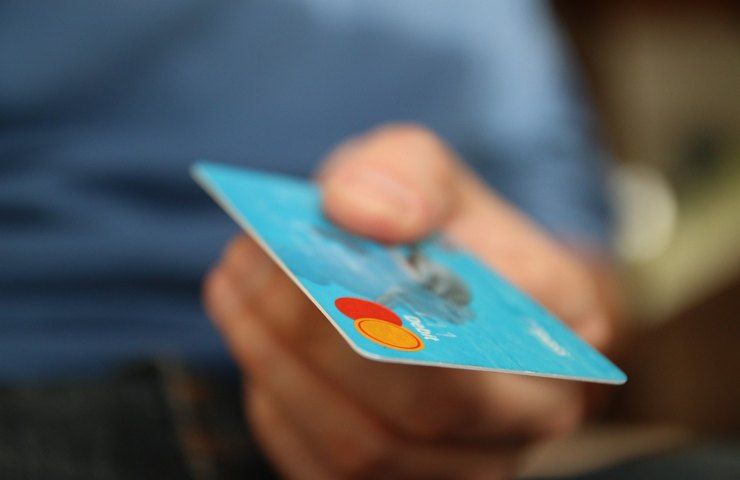 Una persona porge una carta di credito per un pagamento
