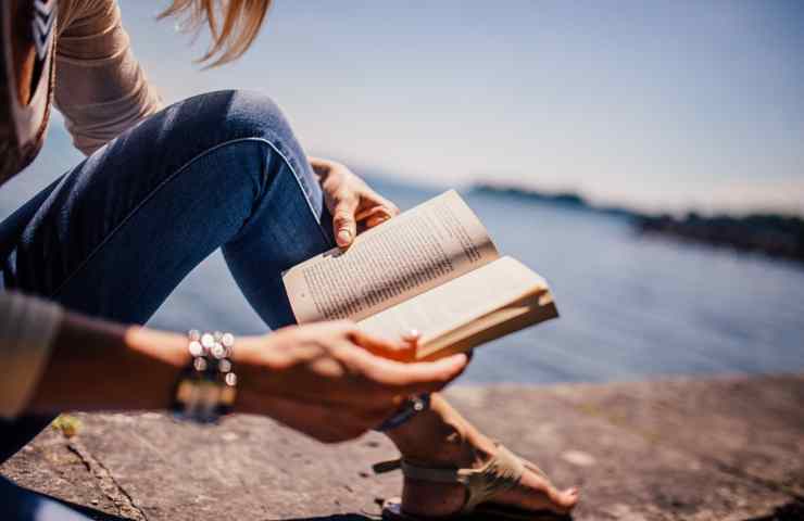 Una ragazza impegnata a leggere all'aperto