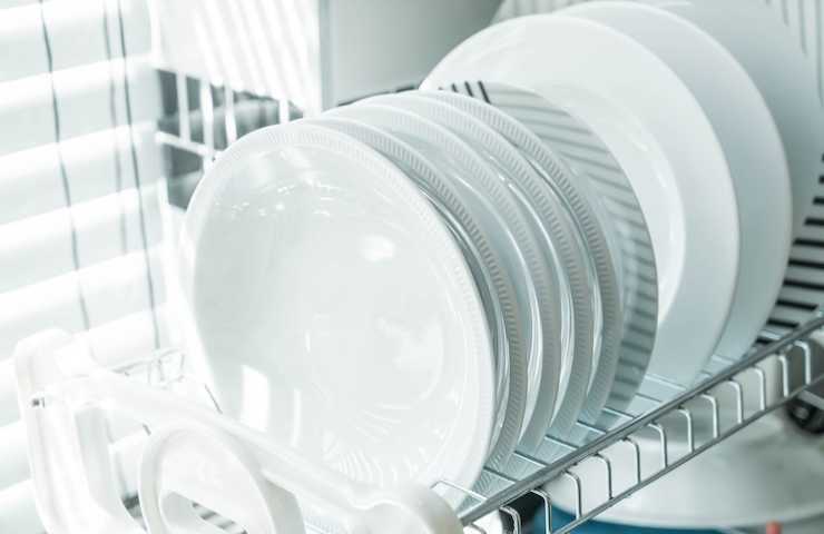 Il cestello di una lavastoviglie carico di piatti