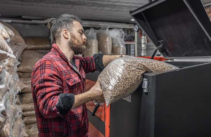 Un uomo carica dei sacchi di pellet