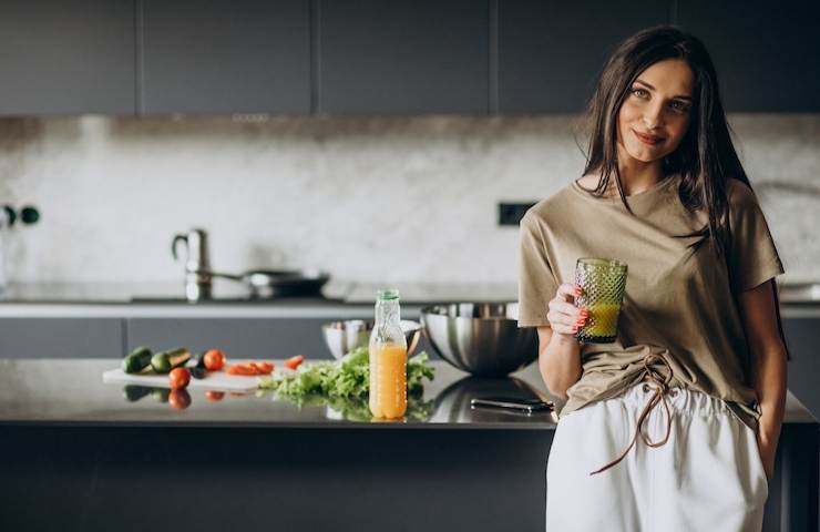 Una donna beve un succo di frutta