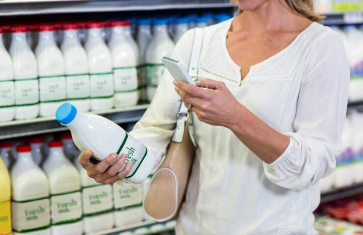 Una donna controlla una bottiglia di latte