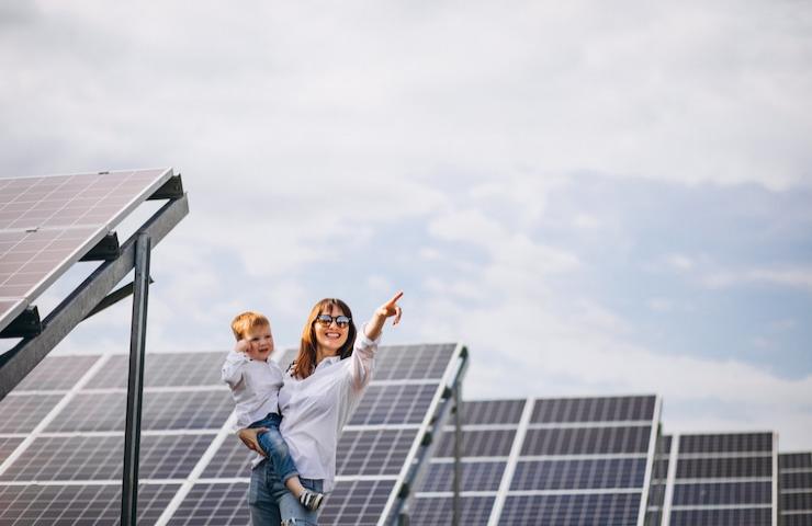 Una donna ed un bambino tra i pannelli solari