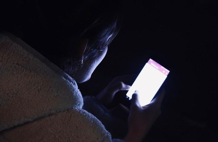 Una persona usa lo smartphone al buio ad alta luminosità