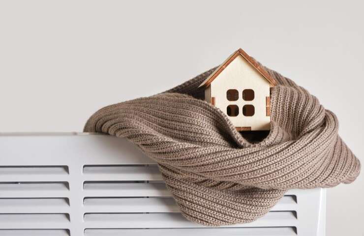 Il modellino di una casa in una sciarpa su un termosifone