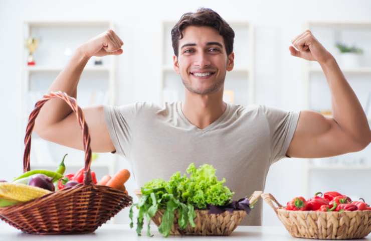 Un uomo allenato e delle verdure