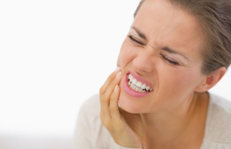 Una donna colpita da mal di denti