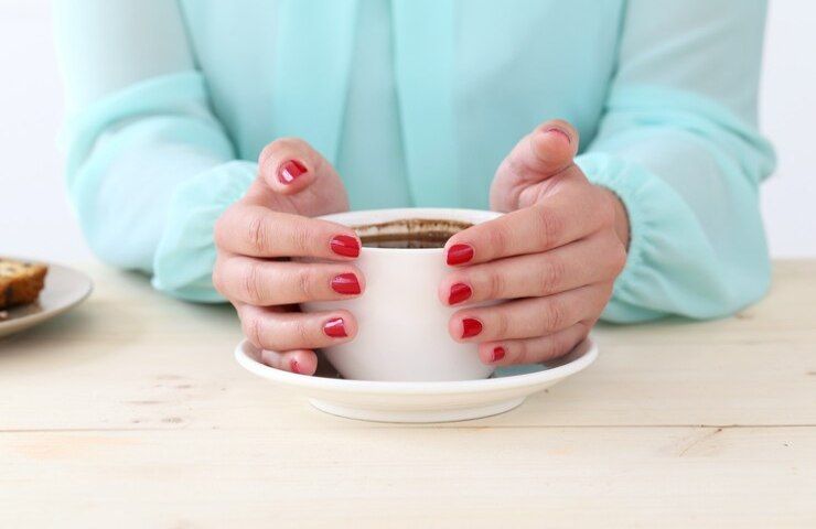 Una donna con del caffè davanti a sé