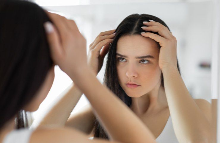 Una donna controlla lo stato dei suoi capelli