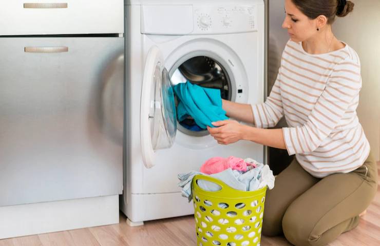 Una donna estrae il bucato dalla lavatrice