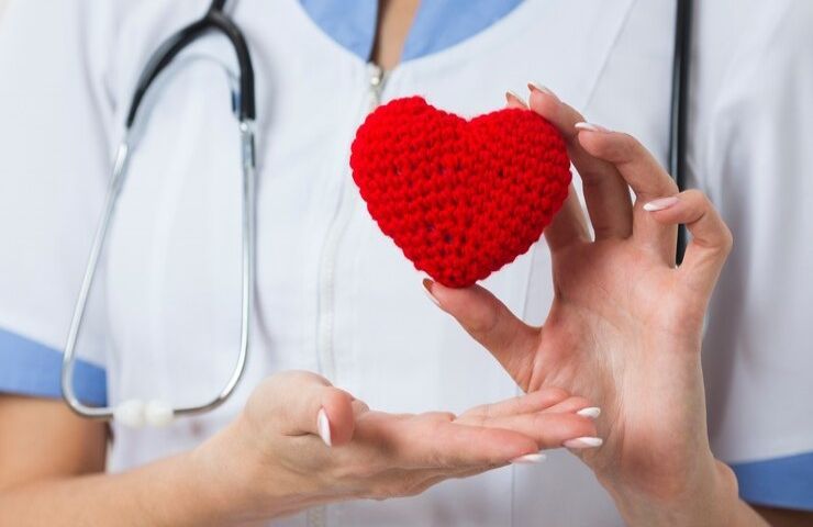 Una dottoressa tiene in mano un cuore di lana rosso