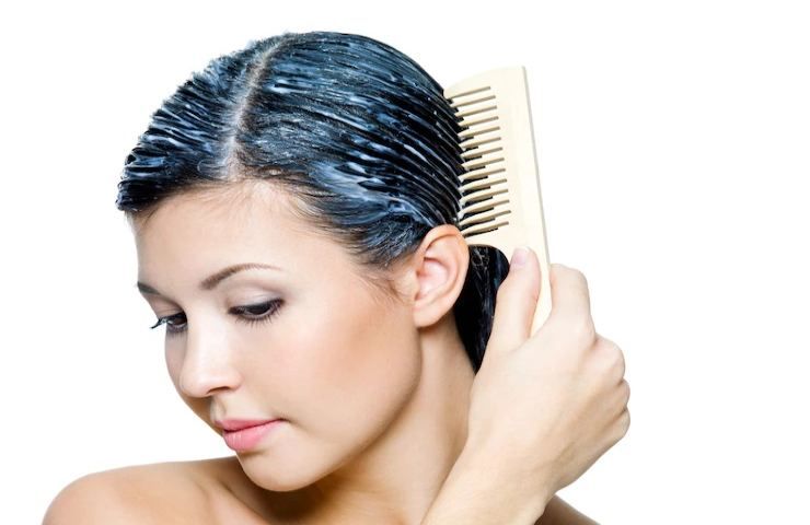 Una ragazza si pettina i capelli appena trattati con olio di ricino