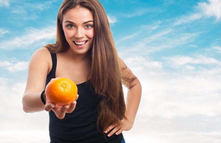 Una ragazza tiene un'arancia in mano