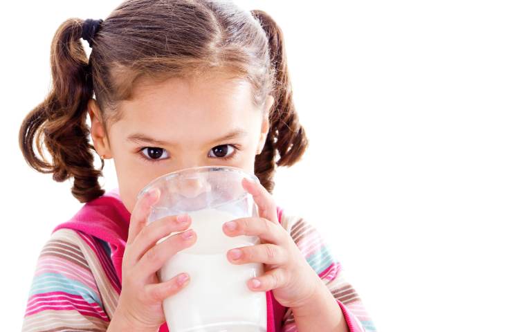Una bambina mentre beve del latte
