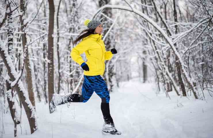 Una donna fa jogging in un paesaggio innevato