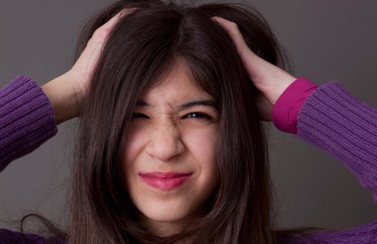 Una ragazza con prurito tra i capelli