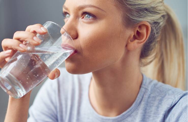 Una ragazza mentre beve dell'acqua calda