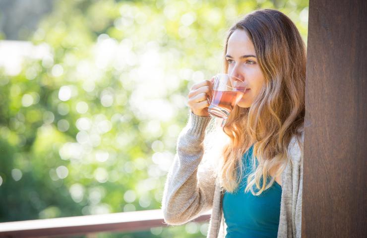 Donna che beve una tazza di tè verde