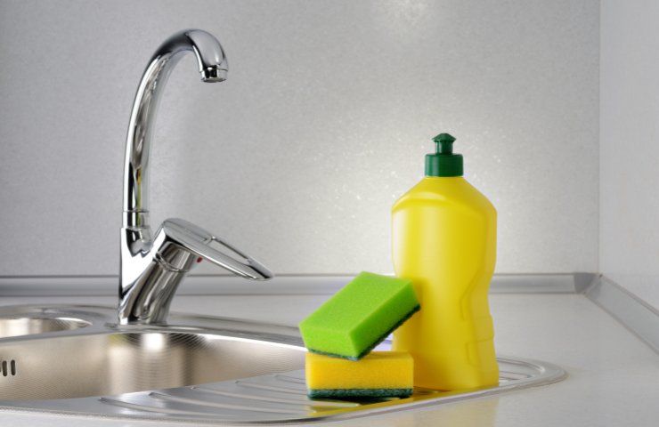 Un detersivo e delle spugnette su un lavabo in cucina