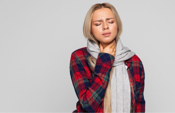 Una donna alle prese con il mal di gola