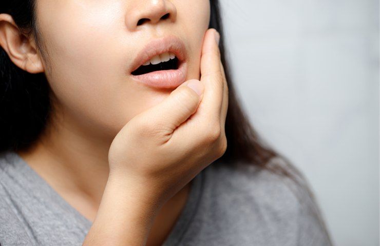 Una donna alle prese con un forte mal di denti