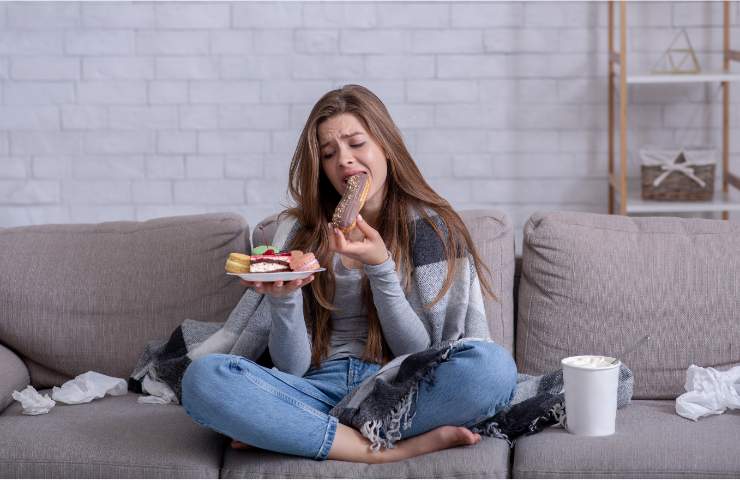 Una donna mentre mangia compulsivamente a letto