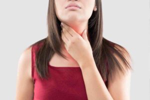 donna si tocca il collo
