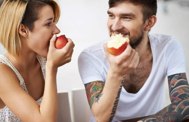 Un uomo ed una donna che mangiano delle mele