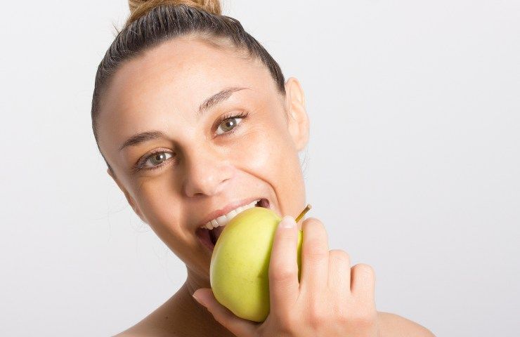 Una donna che mangia una mela