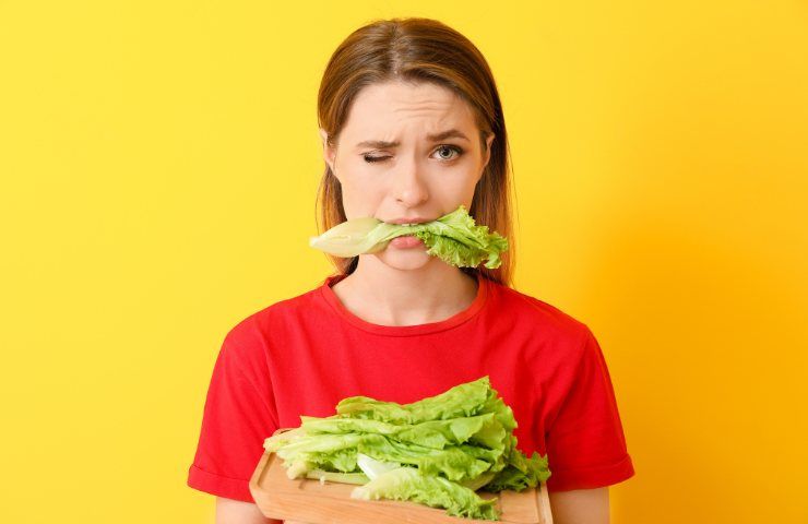 Una donna con della lattuga tra i denti