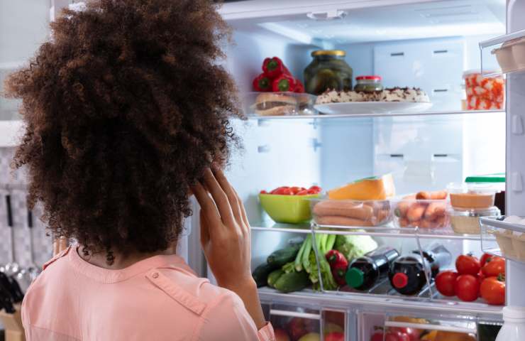 Una donna davanti ad un frigo aperto