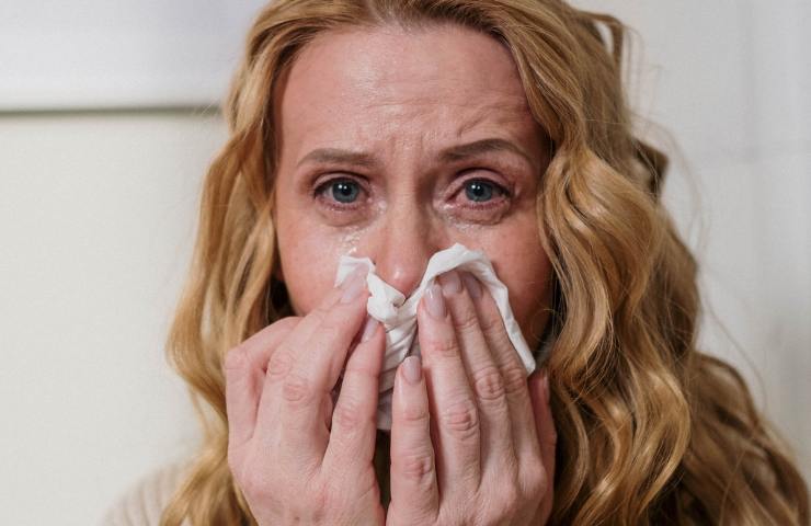 Una donna in preda all'allergia in casa