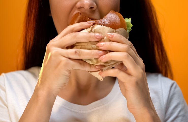 Una donna mentre mangia un panino