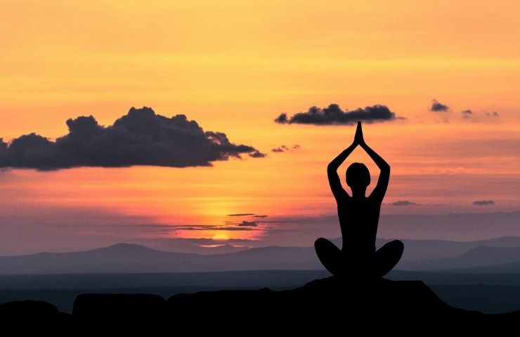 Una donna persona che medita al tramonto