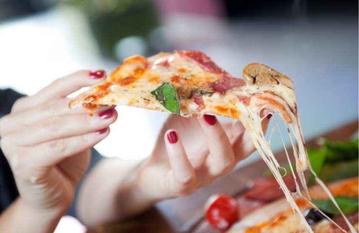 Una persona mentre mangia una pizza