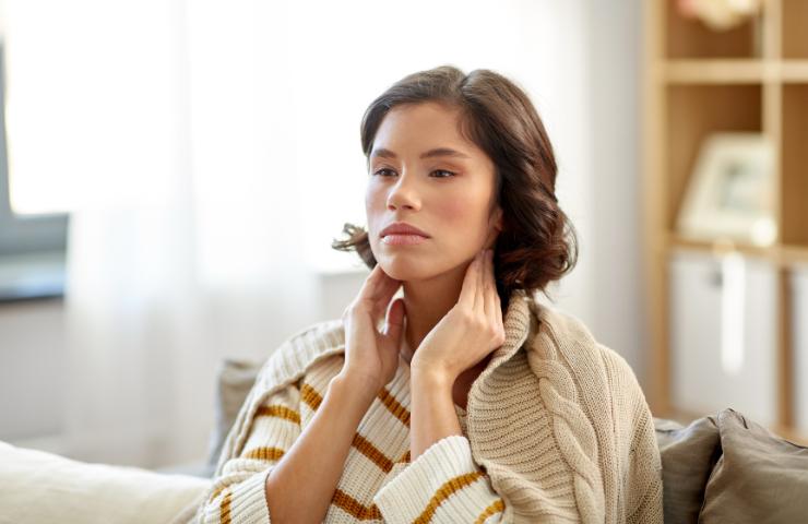 Una ragazza mentre si tocca il collo (Foto Canva - Inran.it 28012023)