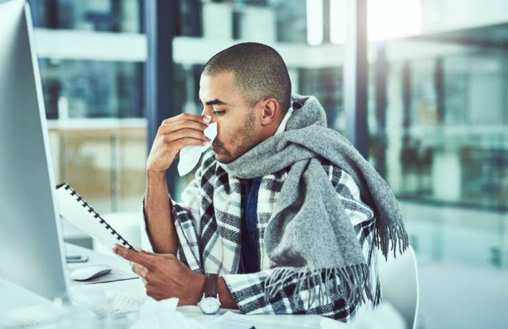 Un uomo al lavoro nonostante abbia l'influenza