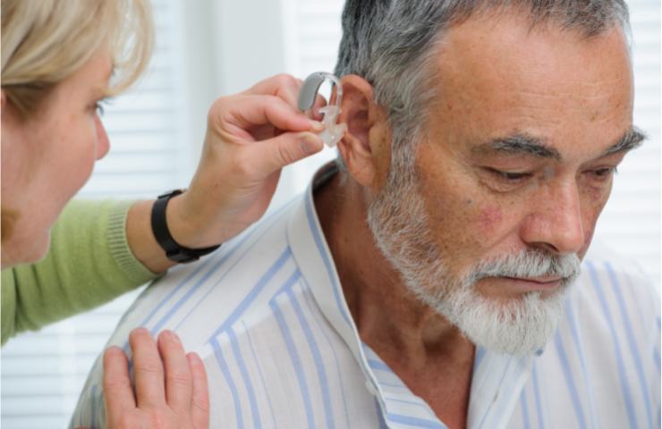 Un uomo riceve un apparecchio per le orecchie