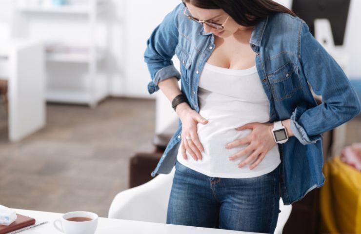 Una donna alle prese con del gonfiore addominale