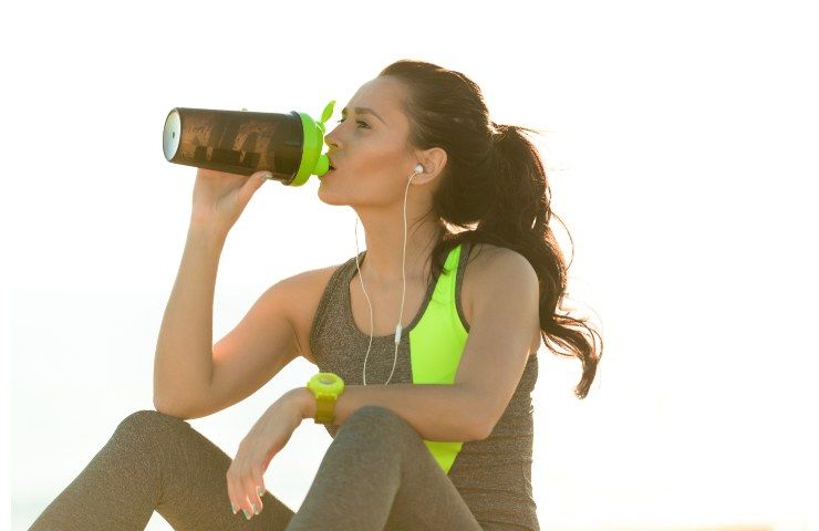 Una donna beve nel corso di una pausa di un allenamento