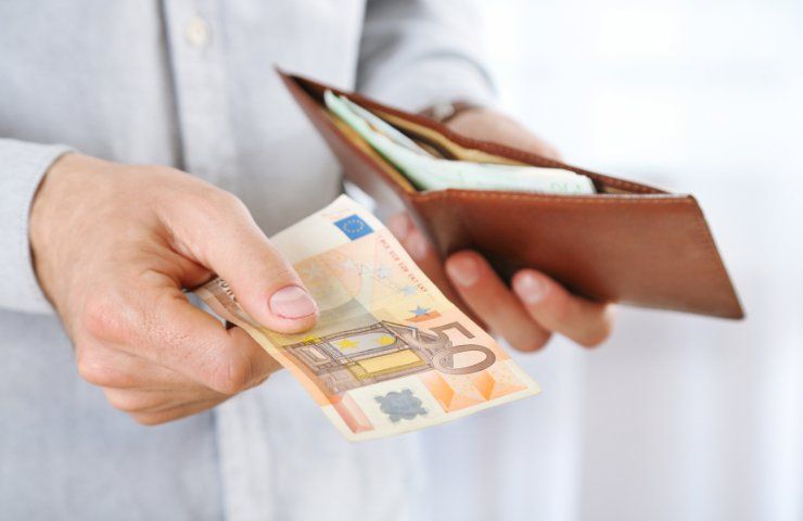 Una persona porge una banconota da 50 euro