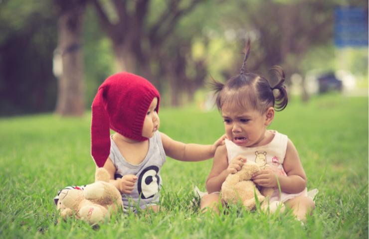 Un bambino che conforta una bimba che piange