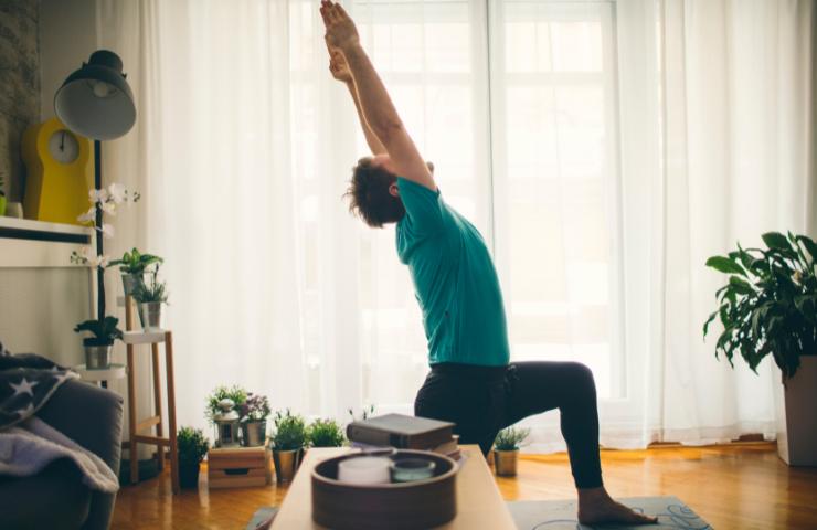 Un uomo che fa yoga a casa