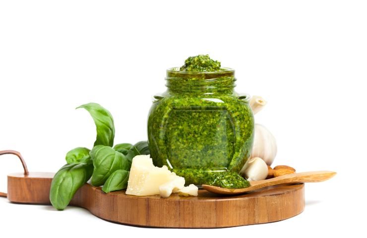 Un vasetto di pesto con del basilico ed altri ingredienti