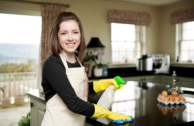 Una donna che pulisce in cucina