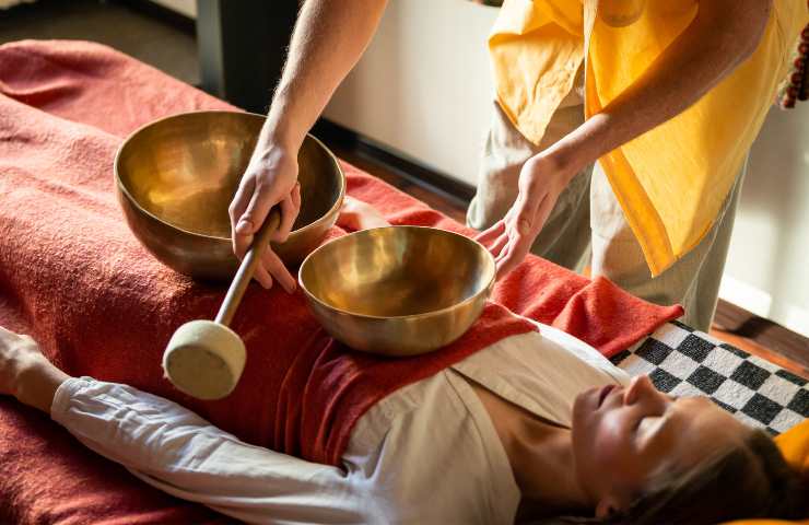 Una donna sottoposta a seduta massaggiante con delle campane tibetane