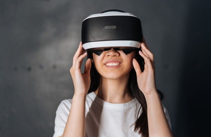 Una ragazza videogioca con il casco della realtà virtuale