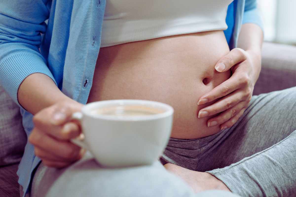 donna incinta con cappuccino in mano