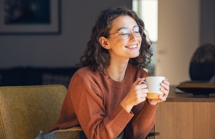 Ragazza sorridente sorseggia tisana