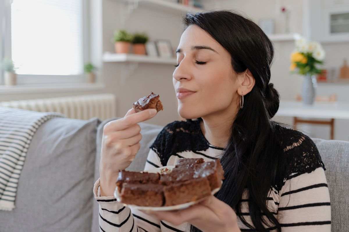 Donna gusta una fetta di torta